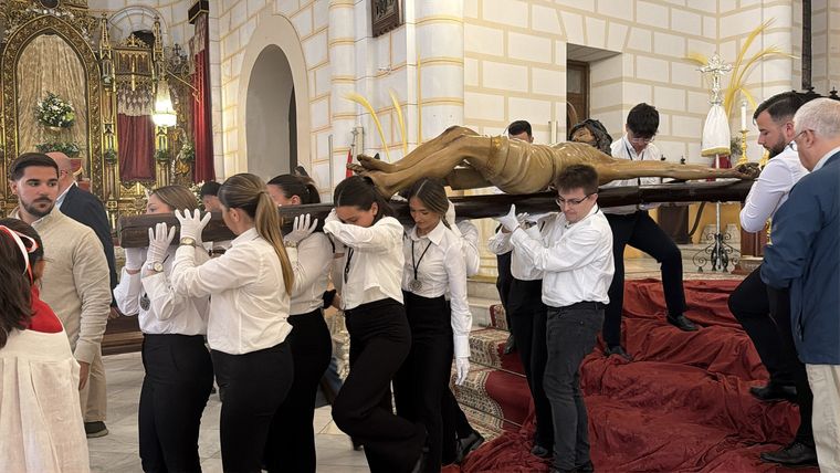 Los jóvenes de la cofradía llevan en brazos al Cristo de la Paz durante el Traslado