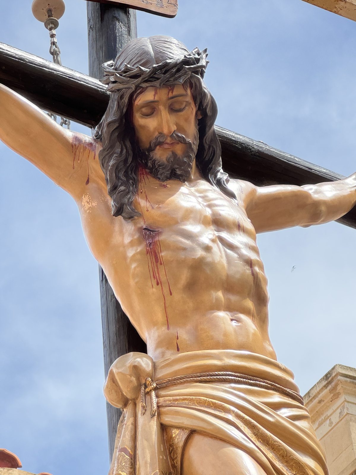 El Santísimo Cristo de la Paz crucificado, recortado contra el cielo de Melilla