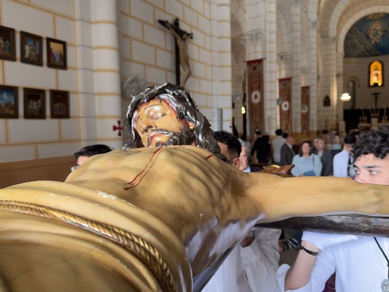 El Cristo de la Paz llevado en brazos por la nave de la parroquia durante el Traslado