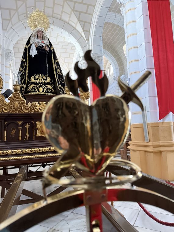 La Virgen de la Soledad al fondo de la nave, vista tras el remate del guion de la cofradía