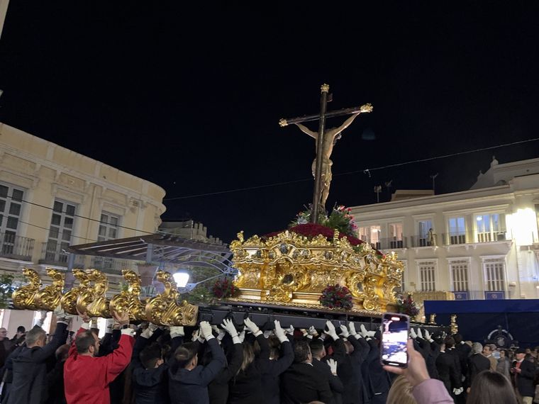 Decenas de manos con guantes blancos levantando el trono del Cristo de la Paz