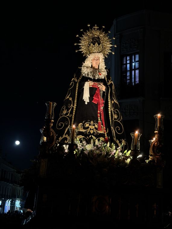 El trono de la Virgen de noche con la luna llena a su izquierda
