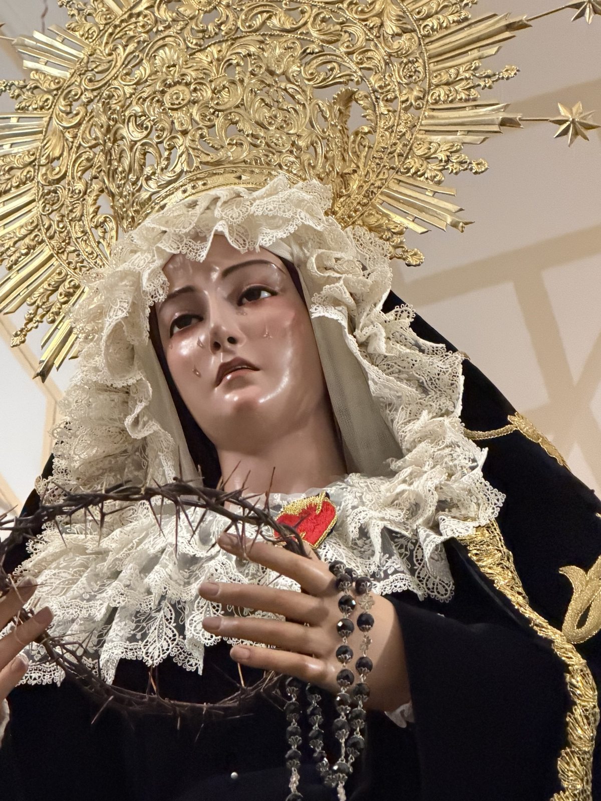 Rostro de Nuestra Señora de la Soledad, con lágrimas, tocado de encaje y corona de oro