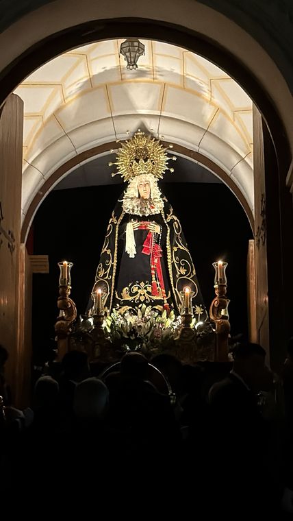 Nuestra Señora de la Soledad saliendo bajo el arco de la puerta de la parroquia, entre la multitud